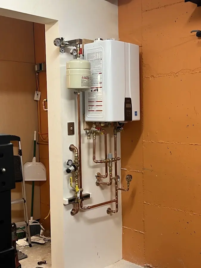 Plumbing technician inspecting water heater connections in Whitewater